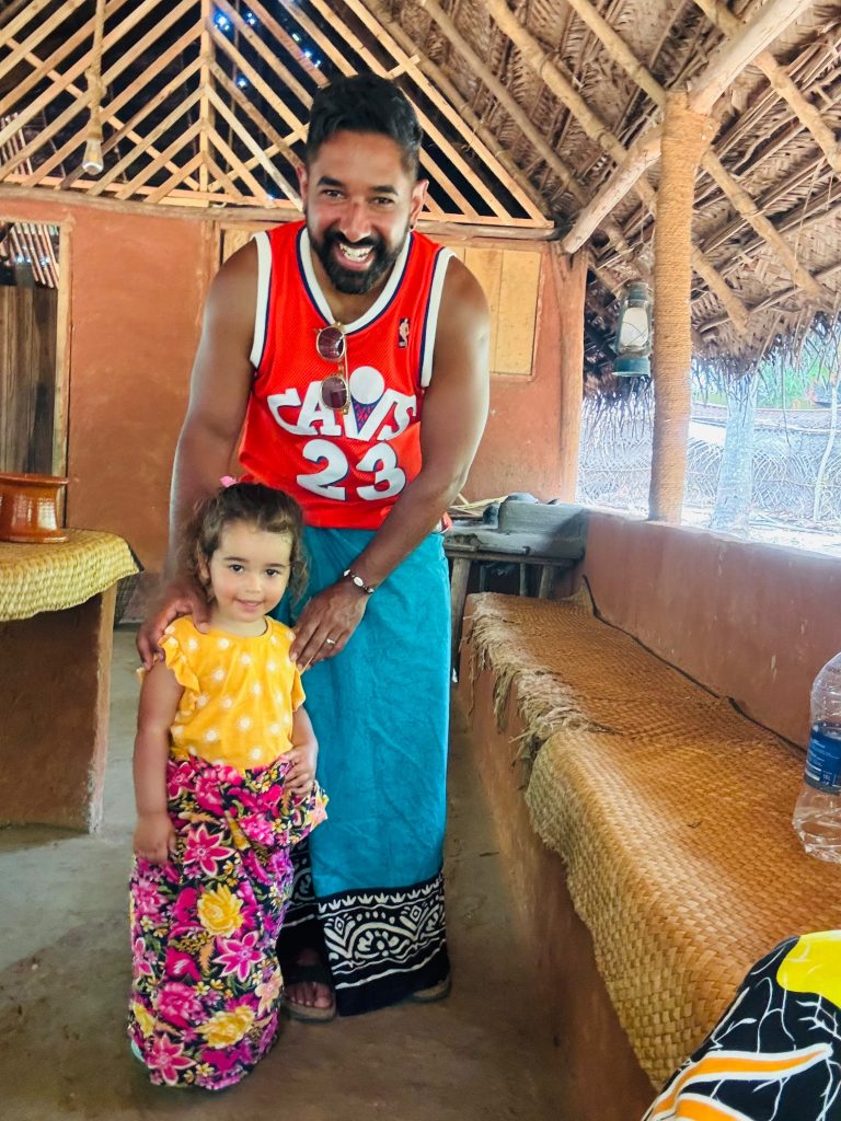 Father and daughter in traditional Sri Lankan sarong inside a village hut - Olanka Tours